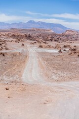 Vertical shot of a road in the Atacama desert in Chile under a cloudy blue sky