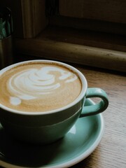 Vertical shot of a cup of fresh espresso served on a wooden surface