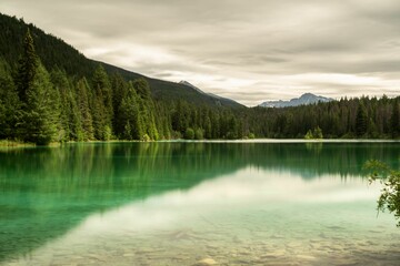 Green Lake surrounded by trees and mountains in the valley of the five lakes in Alberta, Canada