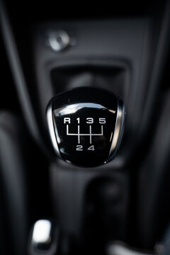 Gear stick knob with leather closeup from top view. Dark black and white manual car interior. Gear lever, gearshift, shifter, transmission lever.	
