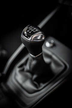 Gear stick with leather closeup from side view. Dark black and white manual car interior. Gear lever, gearshift, shifter, transmission lever.	

