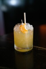 Vertical shot of a delicious margarita cocktail with citrus fruit and ice on the bar