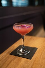 Beautiful cocktail of guava hibiscus martini with orchid garnish