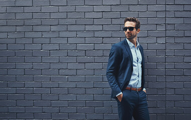 Fashion, suit and man with glasses for confidence, trendy clothes and professional style. Male person, eyewear and gentleman with pose by grey background for classy outfit, elegance and mockup