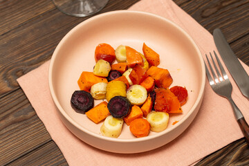 A portion of baked root vegetables, sweet potatoes, carrots