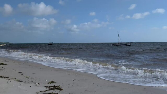 Traditional wooden fishing boats rocking on ocean waves near the shore in Africa