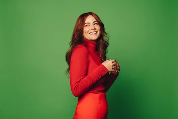 Fototapeten Happy woman with trendy style against green background © Jacob Lund