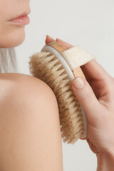 Dry body brush, Woman dry brushing body to reduce cellulite, detoxify the lymphatic system, and...