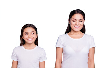 Close up photo amazing pretty two people brown haired mum and small daughter standing straight looking side each other cunning wearing white t-shirts isolated on bright blue background - obrazy, fototapety, plakaty