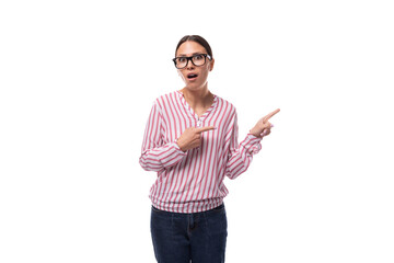 young joyful office worker woman dressed in a pink-white shirt points to an empty space