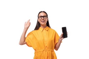 Caucasian young woman with black straight hair wears glasses and a yellow dress