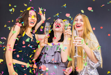 Three young woman having fun with champagne