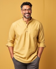 Fototapeta premium A man in a yellow shirt is smiling and posing for a photo