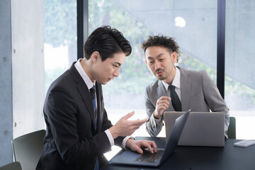 Senior male businessman company employee gently instructing junior employees, training new employees and mentoring newcomers in the company.