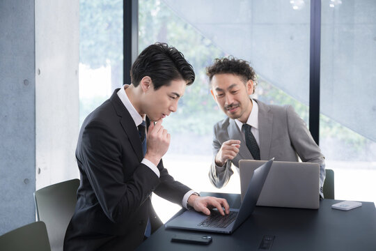 後輩に優しく指導する先輩男性ビジネスマン会社員 　　会社の新人研修や新人指導など