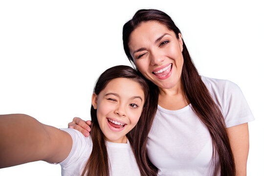 Close up photo cheer beautiful two people brown haired mum mom small little daughter make take selfies mouth laugh laughter flirty wink wear white t-shirts isolated bright blue background