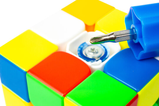 Close-up of a Rubik's Cube with a screwdriver