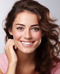 Fototapeta premium A woman with brown hair and a pink shirt is smiling and showing off her teeth