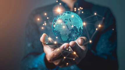 A man is holding a cell phone and a globe in his hand. The globe is glowing and surrounded by a network of lines, giving the impression of a futuristic world