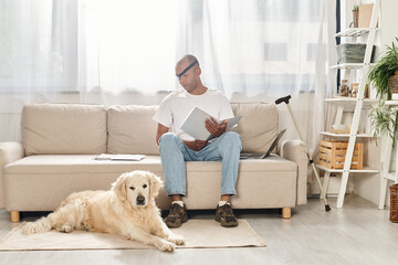 A disabled African American man with myasthenia gravis syndrome relaxes on a couch next to his...