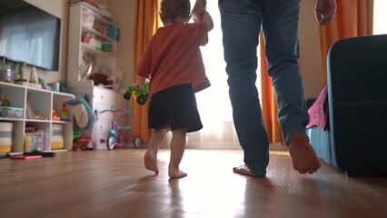 baby first steps with dad. happy family a kid dream concept. dad and baby son walk along the corridor of the house indoors. dad and daughter care, hold hands, walk, take first lifestyle steps