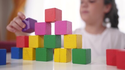 child playing cubes close-up. education a children development of fine motor skills concept. child close-up hands plays with blocks develops fine motor skills. lifestyle kid plays with cubes