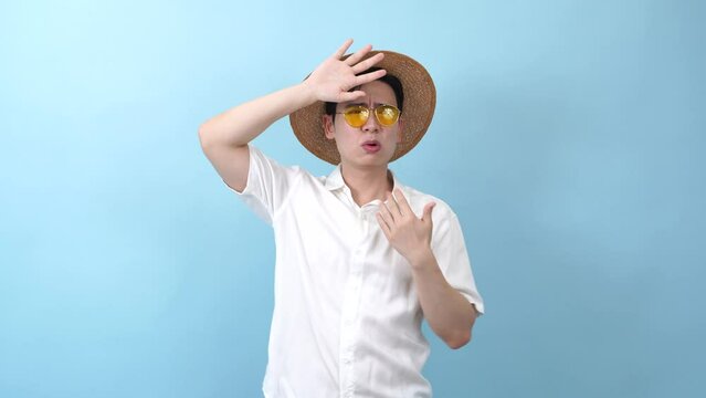 Young Asian man on blue background