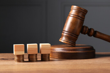 Tax law. Blank wooden cubes, stacked coins and gavel on table