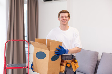 moving, people and real estate concept - happy smiling man holding boxes with stuff at new home