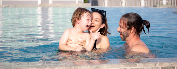 Caucasian family having enjoy and fun together with happiness in swimming pool, summer and holiday, mom, dad and son relax and playful, summertime and vacation, relation and bonding, family concept.