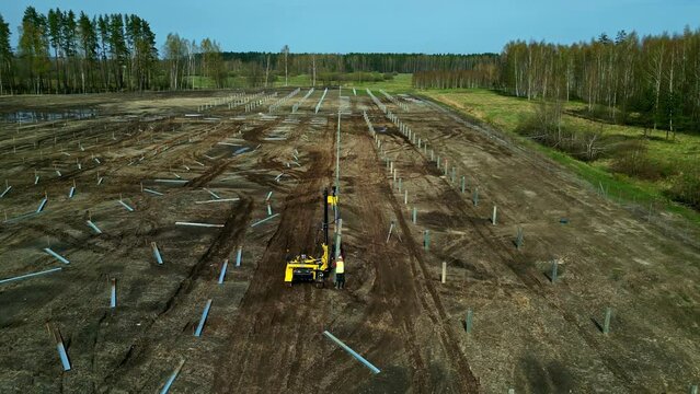 Aerial View Of A Working Solar Pile Driving Equipment In The Fields.  