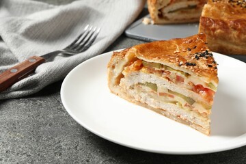 Piece of tasty homemade pie with filling served on grey table