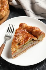 Piece of tasty homemade pie with filling on black table