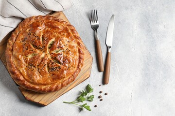 Tasty homemade pie served on light grey table, flat lay. Space for text
