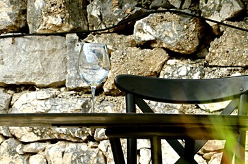 Wine glass on the table against the background of a natural stone wall