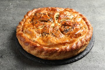 Tasty homemade pie with filling on grey table