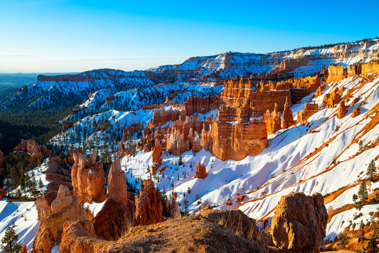 Bryce Canyon National Park in Utah (USA). Giant natural amphitheater panorama at sunrise on a cold winter morning. “Hoodoo“ structures, formed by erosion with snow and warm light. Sight and attraction