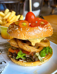 A tantalizing gourmet sandwich with fresh veggies and creamy sauce, served with crispy fries and a...