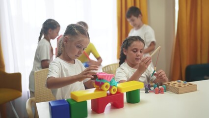 child group playing fishing. children in kindergarten play with toys. happy family kid dream lifestyle concept. a group of children collect building blocks in a kindergarten indoors