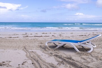 Obraz premium The beautiful sandy beach on a summers sunny day showing a blue and white sun lounger on the beach taken on a beach in the town of Varadero in Cuba