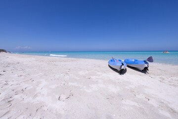 The beautiful beach front of the Cuban town of Varadero in Cuba showing two canoes on the sandy...
