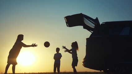 family traveling by car. family watching the sunset silhouette next to the car in the park. family...