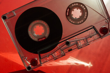Silhouette of audio cassettes and glare on a red background.