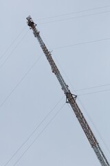 Low angle view of communications tower against cloudy sky.