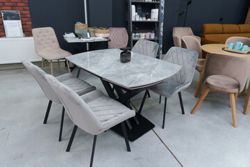 Gray wooden table complete with gray wooden chairs with soft fabric upholstery. Black glass jar...