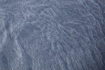 Abstract water surface with ripples and waves as background, top view.