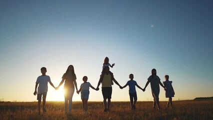 big family. huge community family holding hands walking in the park at sunset. happy family kid dream concept. big family community sunlight walking with children in the park. friendly people walking