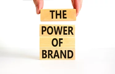 Fotobehang The power of brand symbol. Concept words The power of brand on beautiful wooden block. Beautiful white table white background. Businessman hand. Business the power of brand concept. Copy space. © Dzmitry