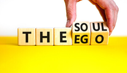 Soul or ego symbol. Concept word The soul or The ego on beautiful wooden cubes. Beautiful yellow table white background. Psychologist hand. Psychological soul or ego concept. Copy space.