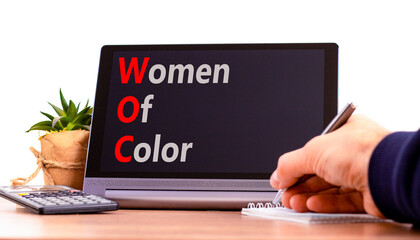 WOC women of color symbol. Concept words WOC women of color on beautiful black tablet. Beautiful white background. Businessman hand. Business WOC women of color social issues concept. Copy space. - obrazy, fototapety, plakaty